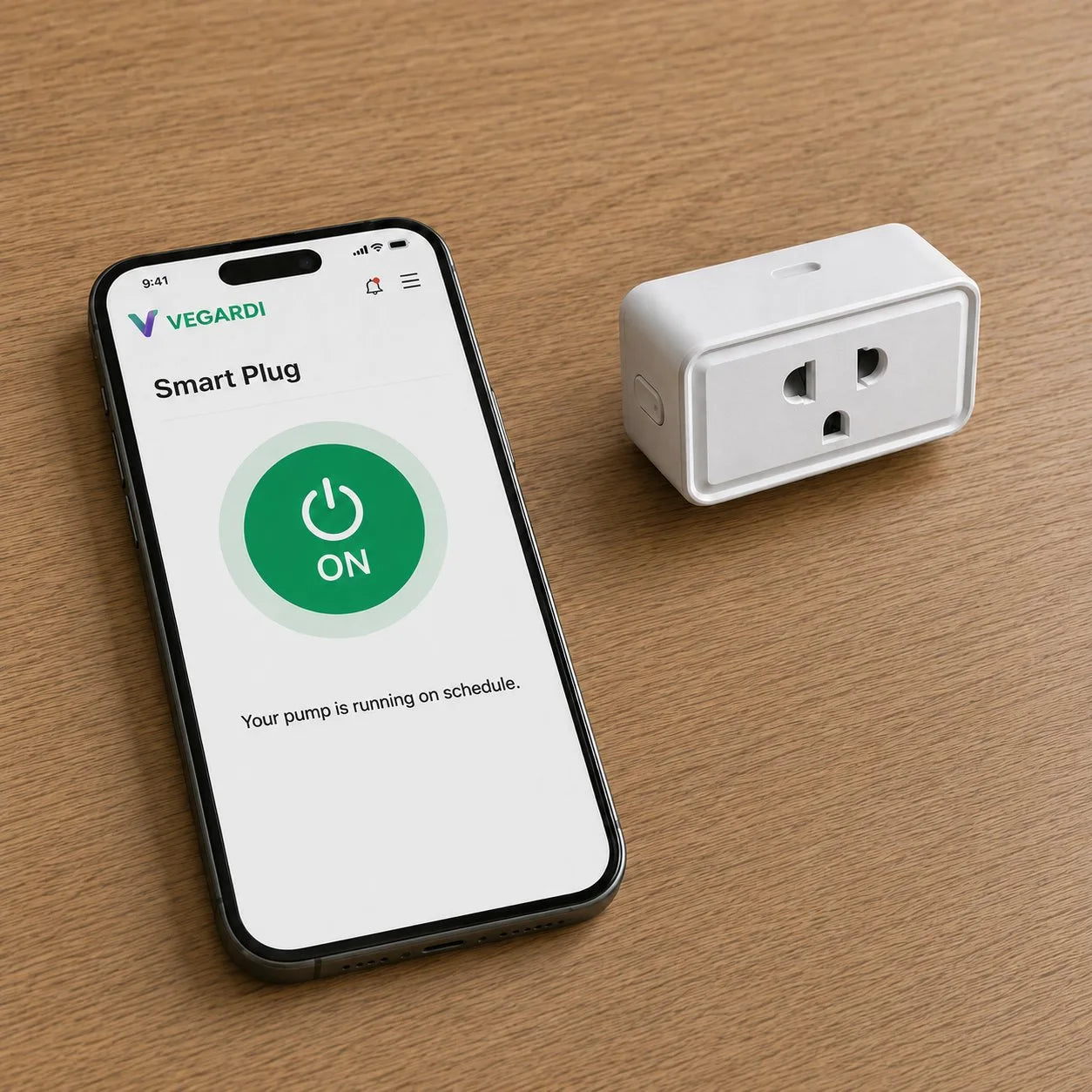 A phone showing the Vegardi Smart Plug control screen with a large green ON button reading 'Your pump is running on schedule,' next to the white IoT smart plug on a wooden surface